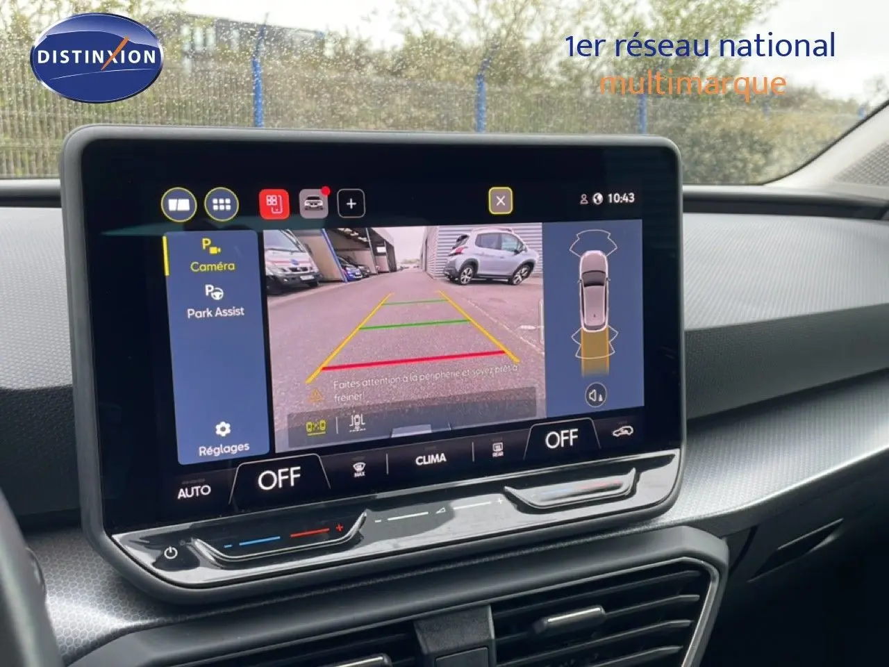 Écran tactile central affichant la caméra de recul et l'assistance au stationnement dans une SEAT LEON bleu Fjord 2025.