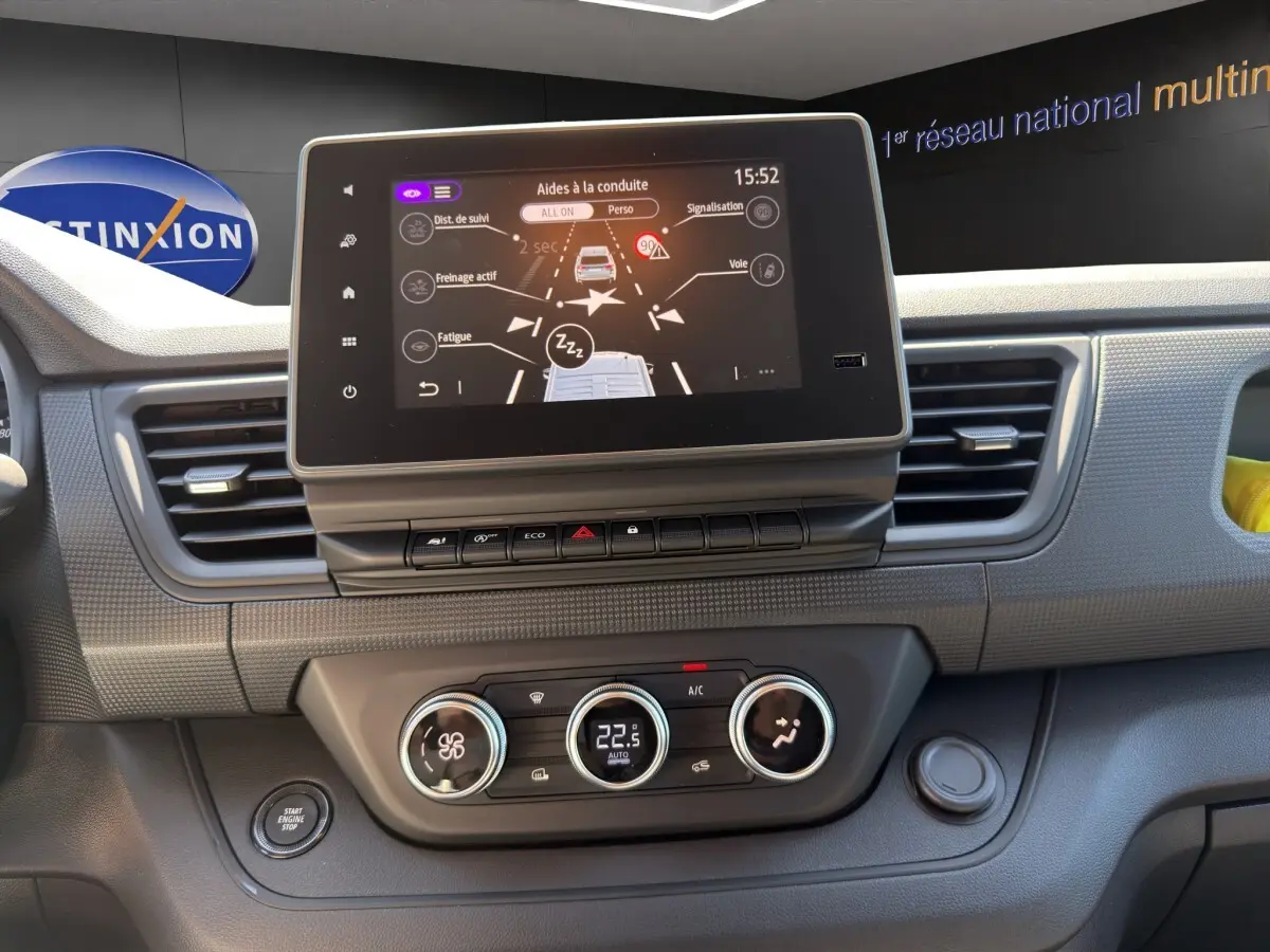 Tableau de bord du Renault Trafic Fourgon 2025 avec écran tactile central et commandes de climatisation en gros plan.