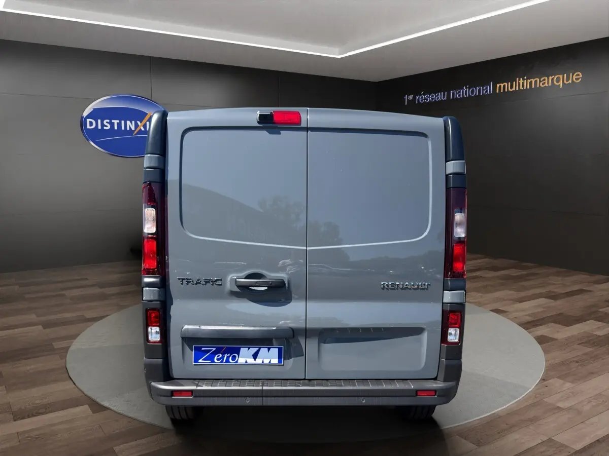 Vue arrière du Renault Trafic Fourgon gris foncé, portes battantes fermées avec logo et feux verticaux rouges.