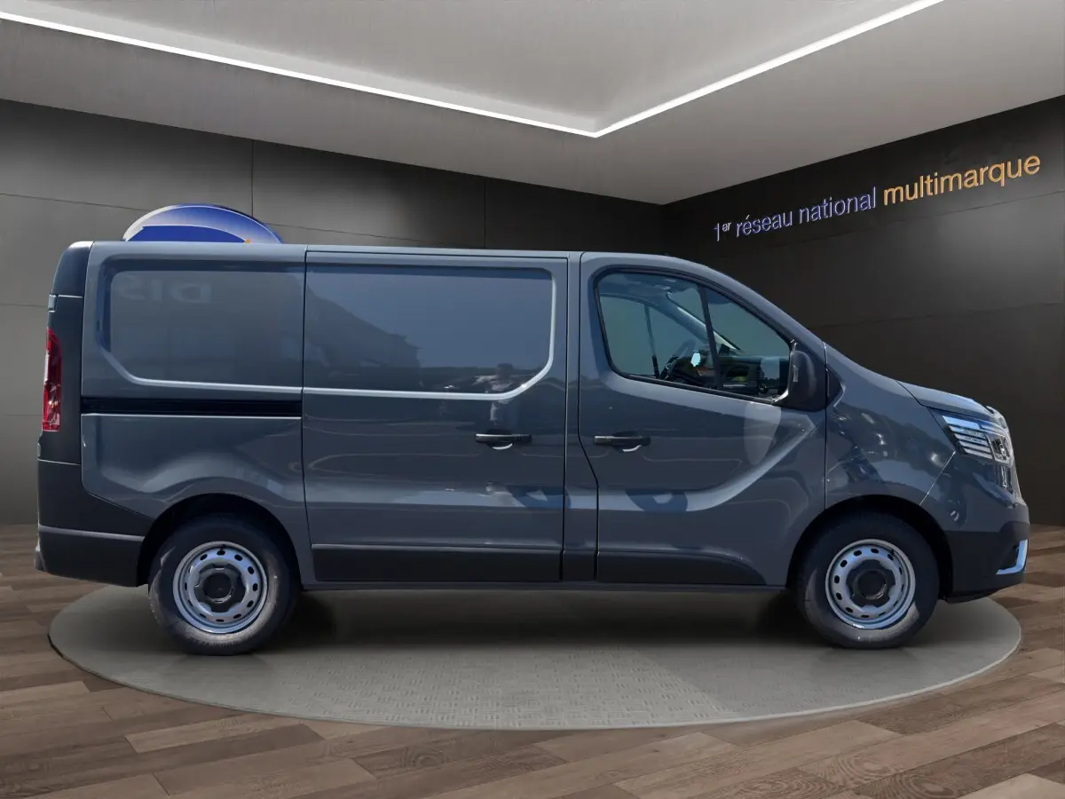 Vue de profil côté gauche d'un Renault Trafic Fourgon gris foncé avec jantes acier et vitres teintées.