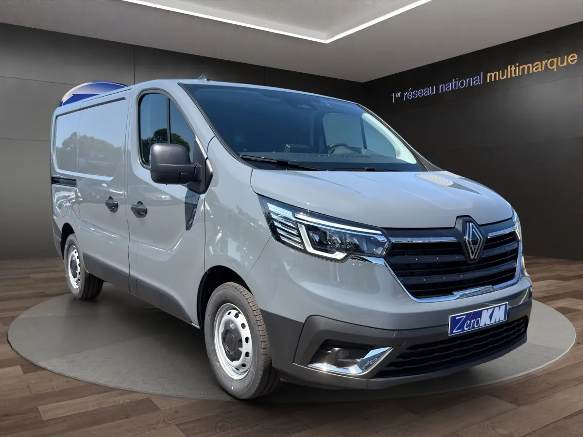 Renault Trafic Fourgon gris foncé en 3/4 avant droit, avec phares LED et jantes acier visibles.