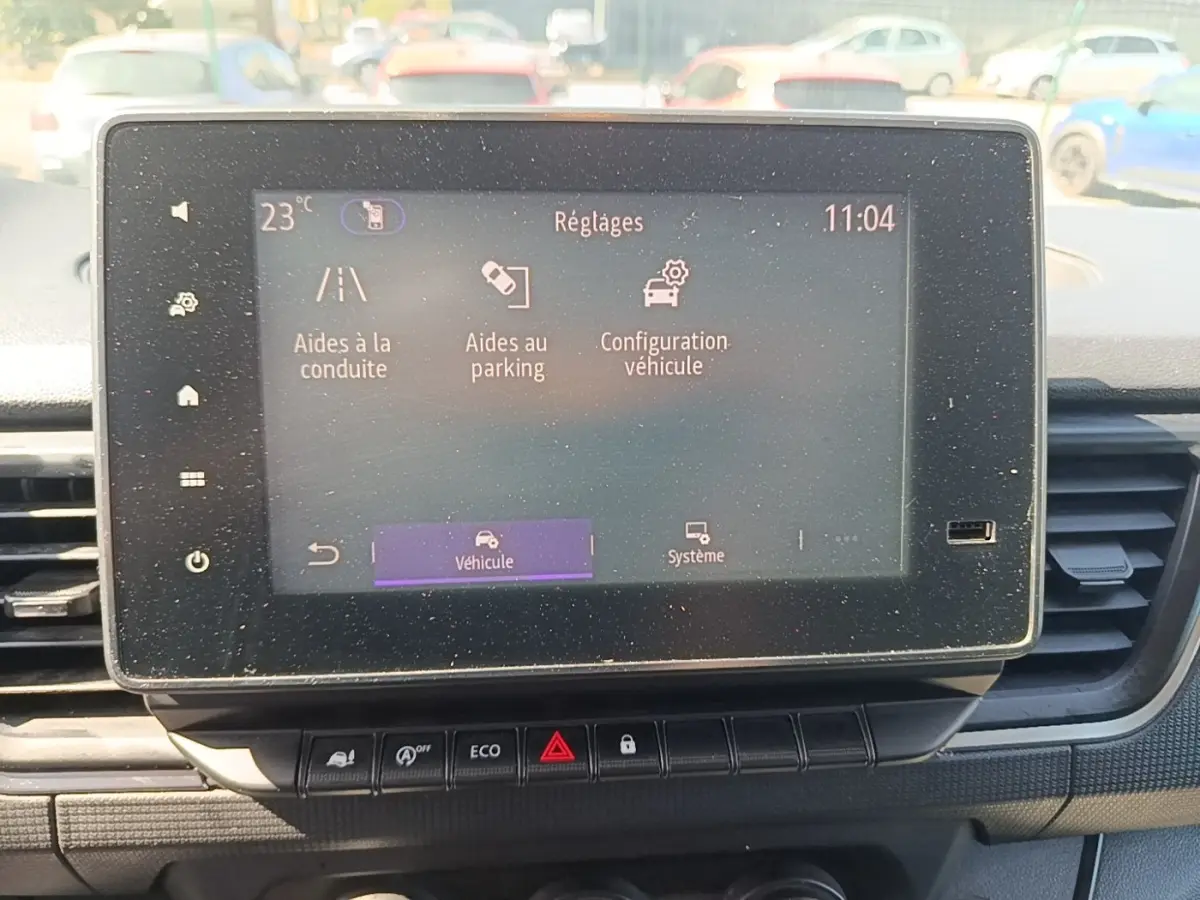 Écran tactile central du Renault Trafic Fourgon blanc, affichant les réglages d’aides à la conduite et parking.