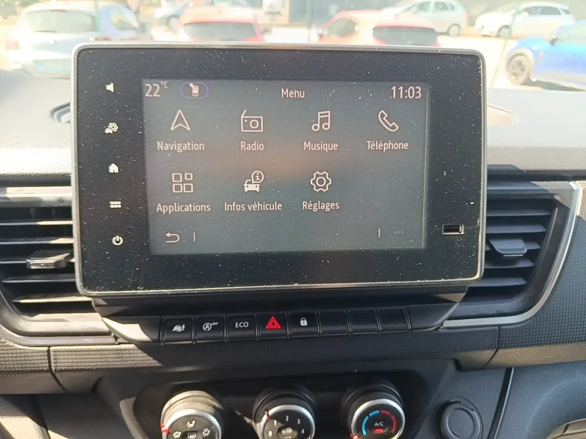 Écran tactile central du tableau de bord du Renault Trafic Fourgon blanc, avec commandes climatisation et boutons fonctionnels.