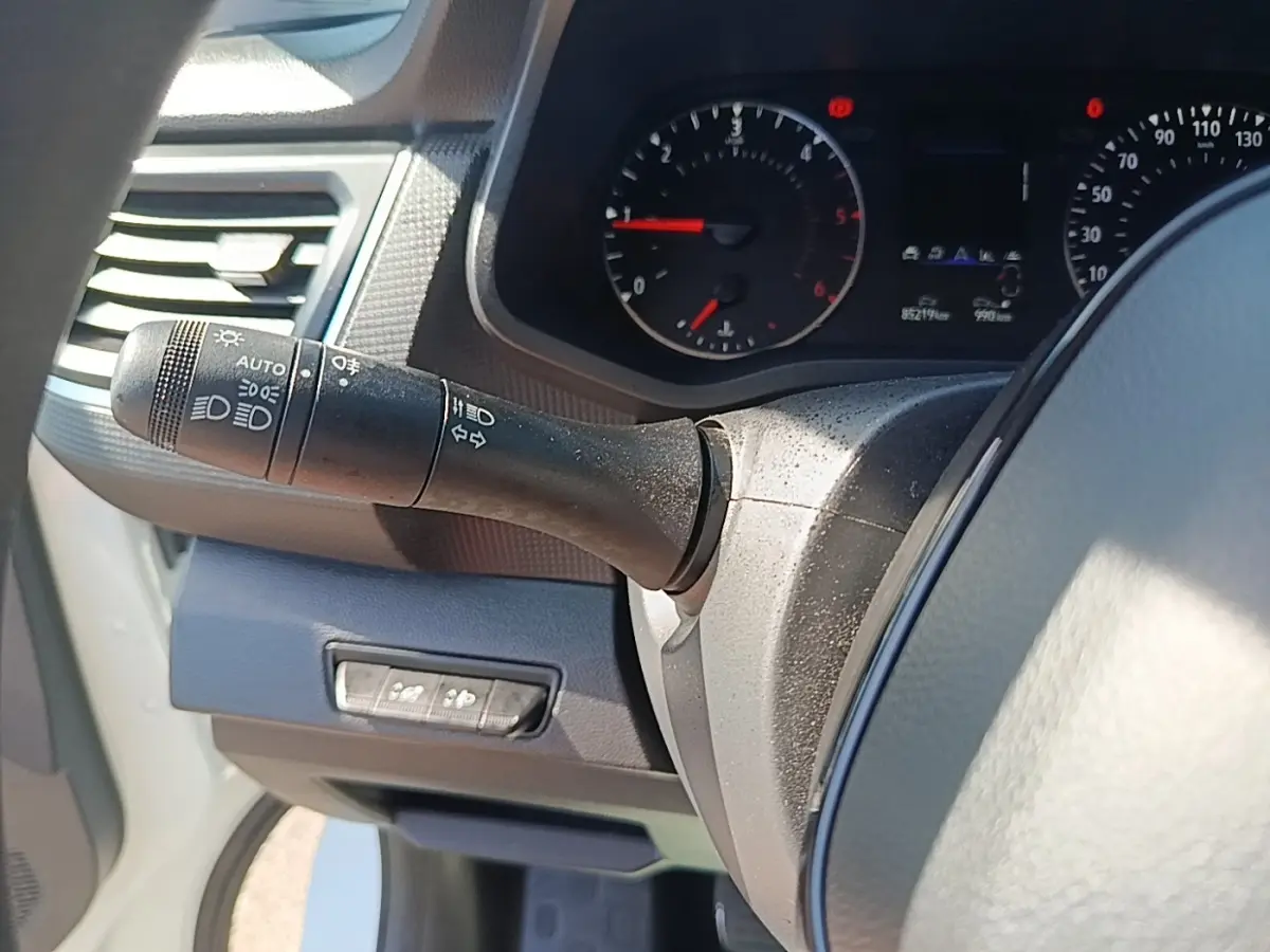Vue intérieure rapprochée du tableau de bord et du commodo d’éclairage du Renault Trafic Fourgon blanc 2023.