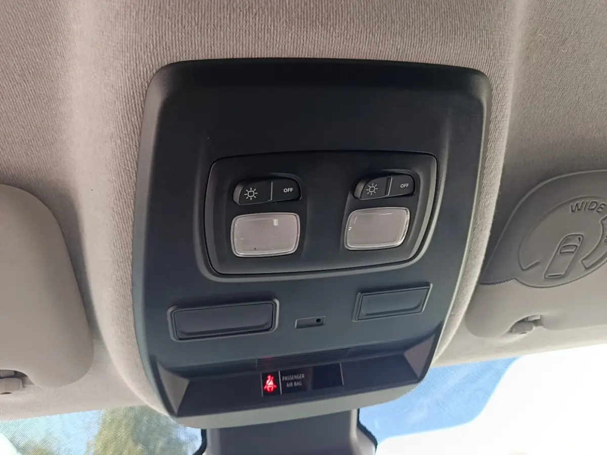 Plafonnier intérieur avec commandes d’éclairage et témoin airbag passager, vue du poste de conduite Renault Trafic Fourgon blanc.