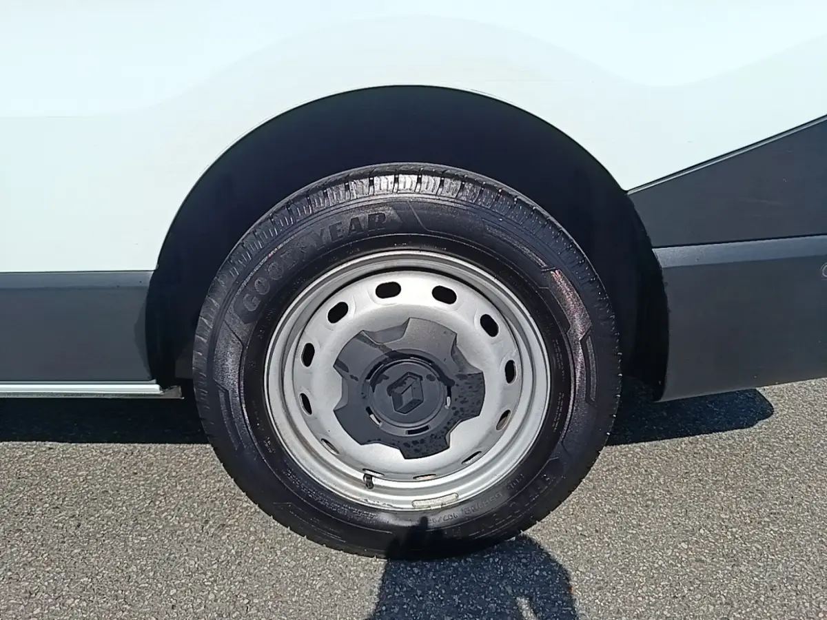 Gros plan sur la roue arrière droite en jante acier grise du Renault Trafic Fourgon blanc, avec logo Renault au centre.