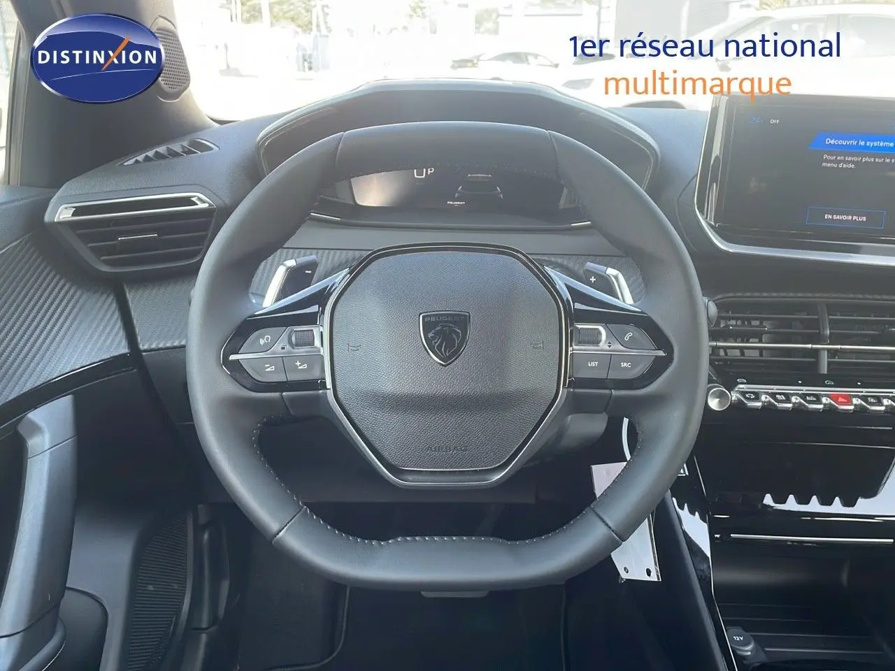 Vue rapprochée du volant compact noir du Peugeot 2008 Hybrid 136ch Allure avec tableau de bord moderne.