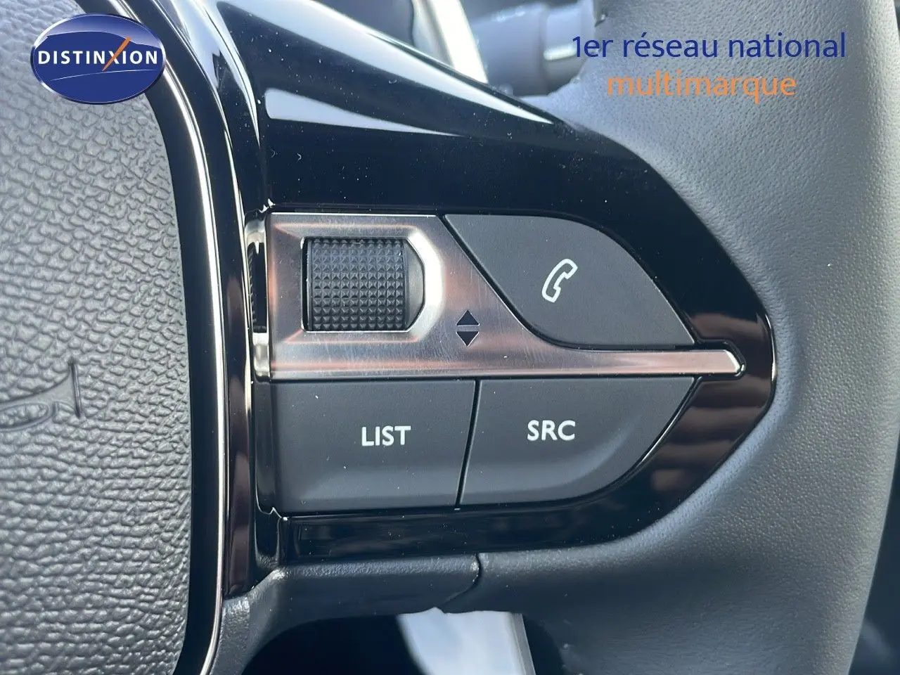 Gros plan sur les commandes du volant du Peugeot 2008 gris Artense, mettant en valeur les boutons LIST et SRC.