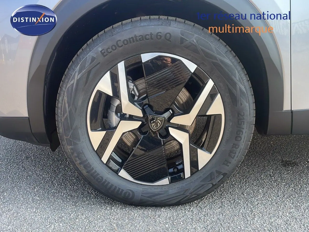 Gros plan sur la roue avant droite du Peugeot 2008 Hybrid gris Artense métal avec jante alliage bicolore moderne.