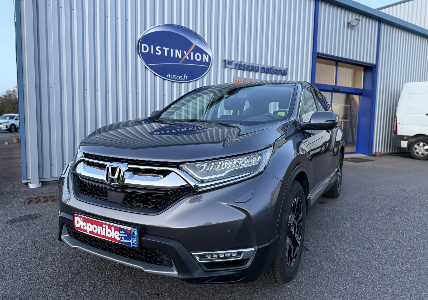 Vue 3/4 avant droite d'un Honda CR-V Hybrid 184 Elegance gris métallisé avec calandre chromée et feux LED.