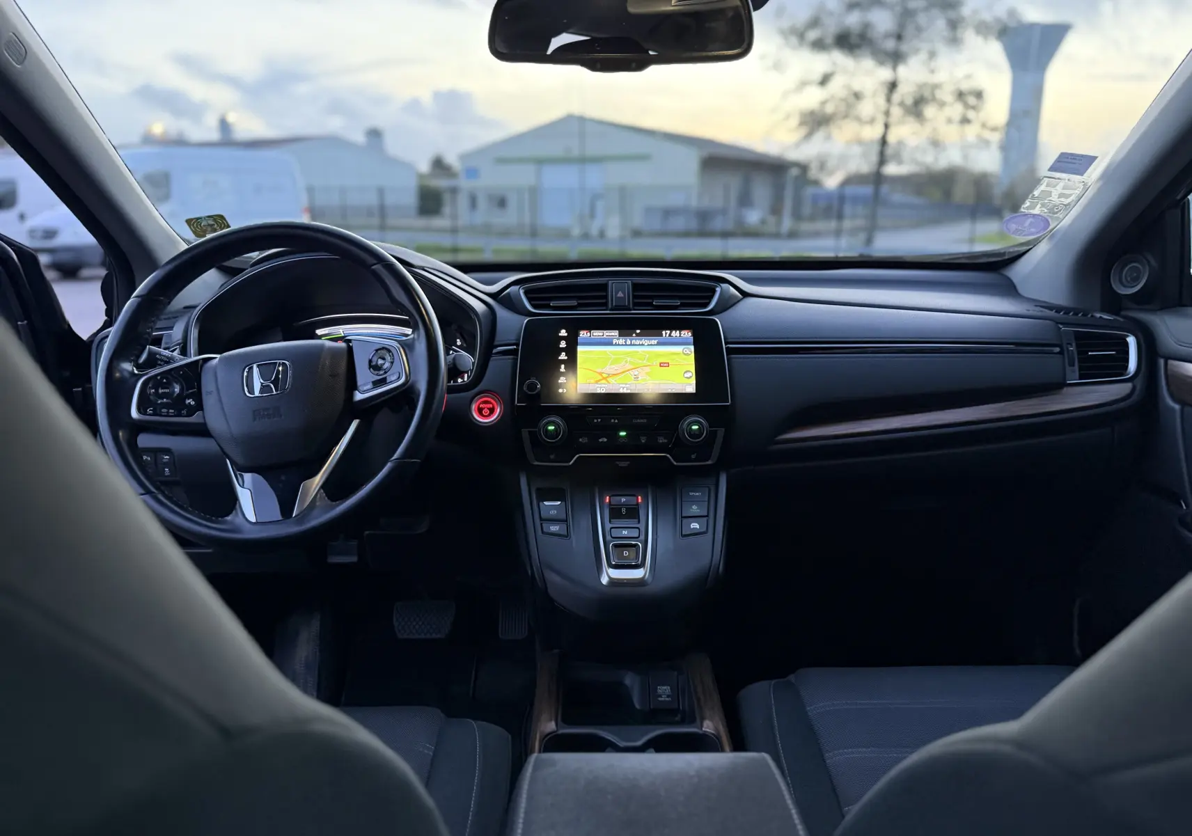Intérieur du Honda CR-V Hybrid 2019 vu de l'arrière, tableau de bord noir avec écran tactile et volant multifonction.