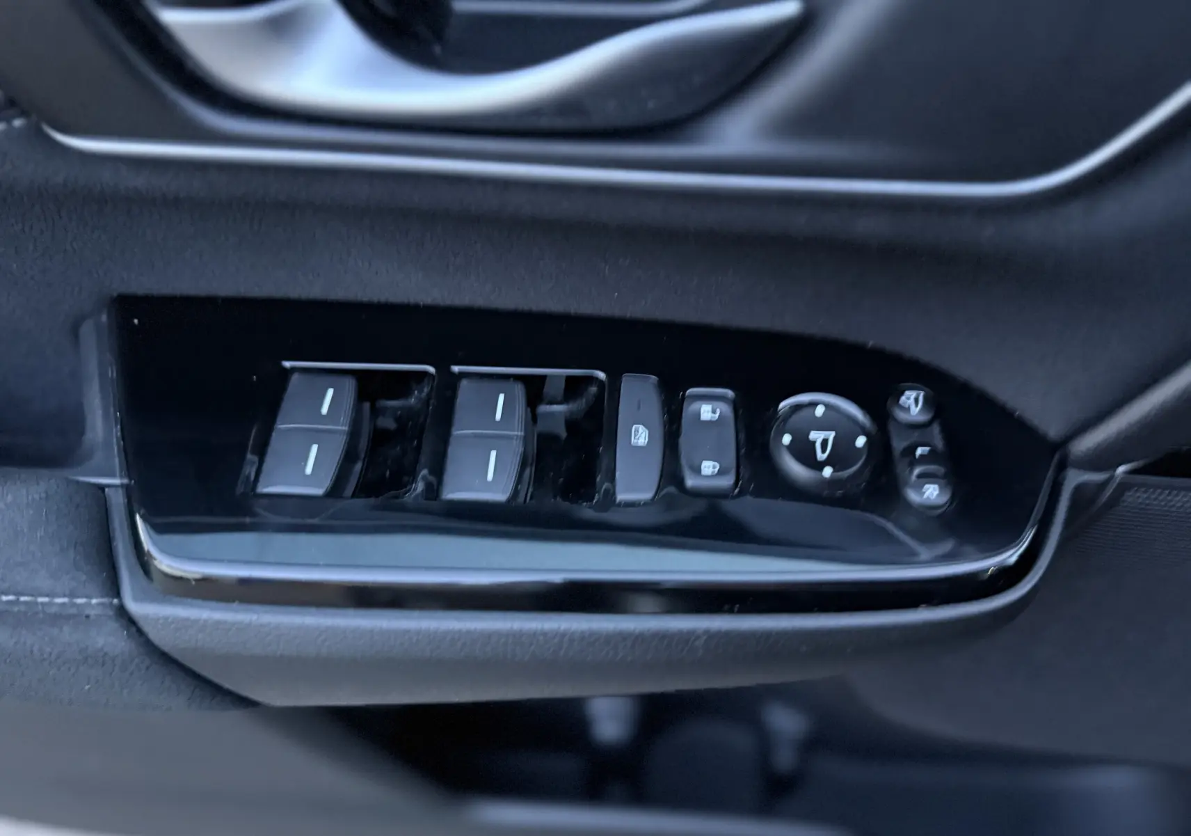 Gros plan sur les commandes de lève-vitres et rétroviseurs côté conducteur du Honda CR-V Hybrid gris 2019.