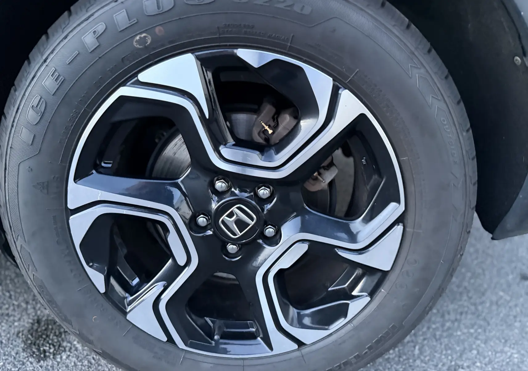 Gros plan sur la jante noire et argentée du Honda CR-V Hybrid 2019, mettant en valeur le logo Honda central.