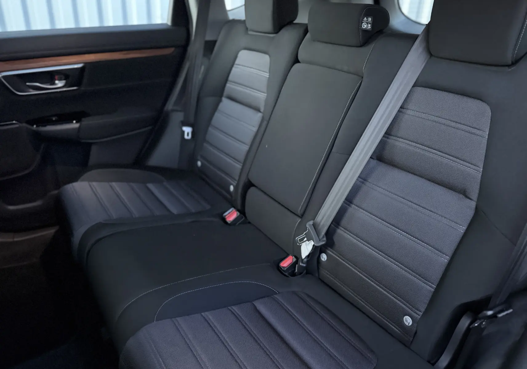 Vue intérieure du siège arrière en tissu noir du Honda CR-V Hybrid 184 Elegance 2019, avec ceinture de sécurité grise.