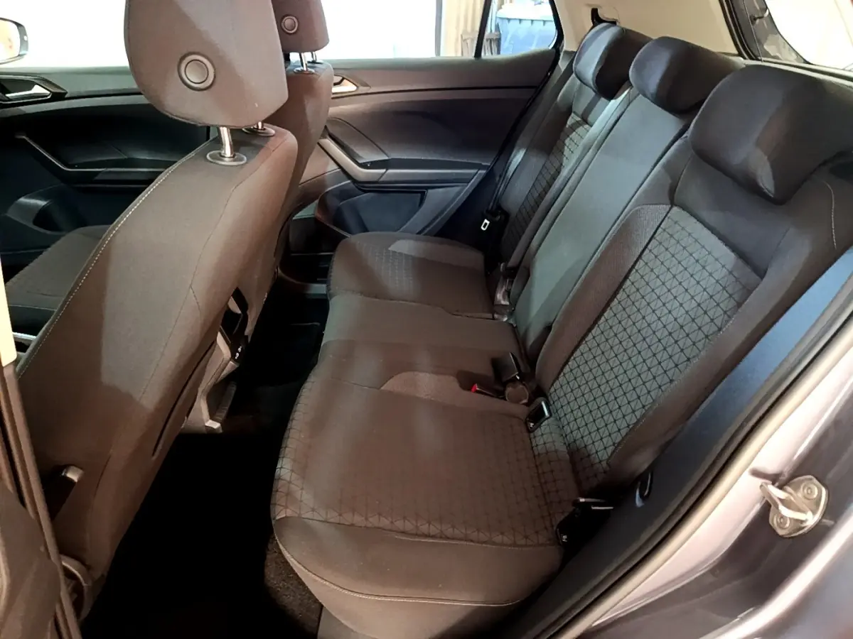 Vue intérieure côté droit montrant la banquette arrière grise foncée du Volkswagen T-Cross 2023 avec appuie-têtes intégrés.