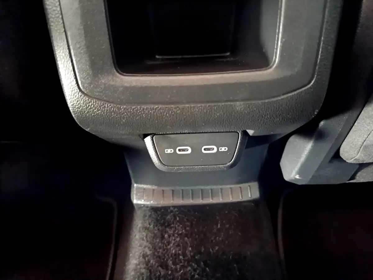 Vue rapprochée des prises USB arrière du Volkswagen T-Cross gris foncé, version 2023, à l'intérieur du véhicule.