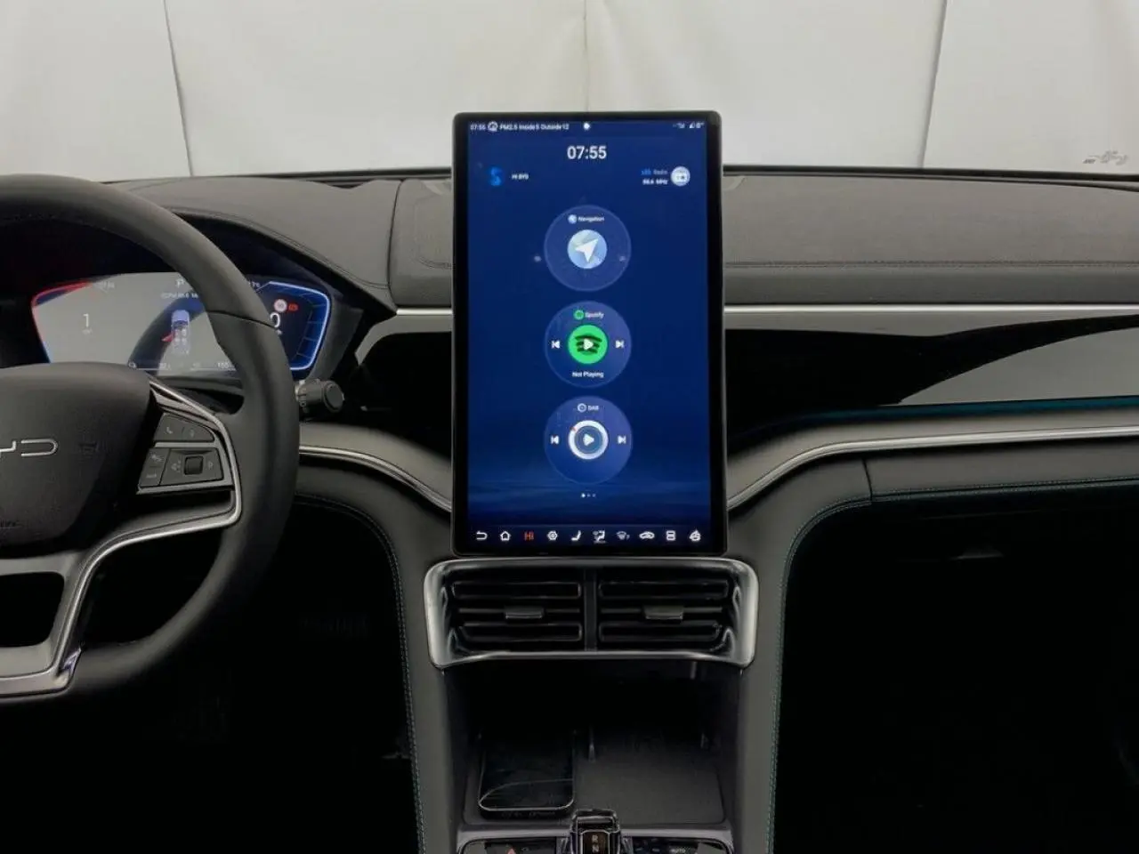 Vue intérieure centrée sur la console tactile verticale du BYD SEAL U 2025, volant à gauche, ambiance noire élégante.