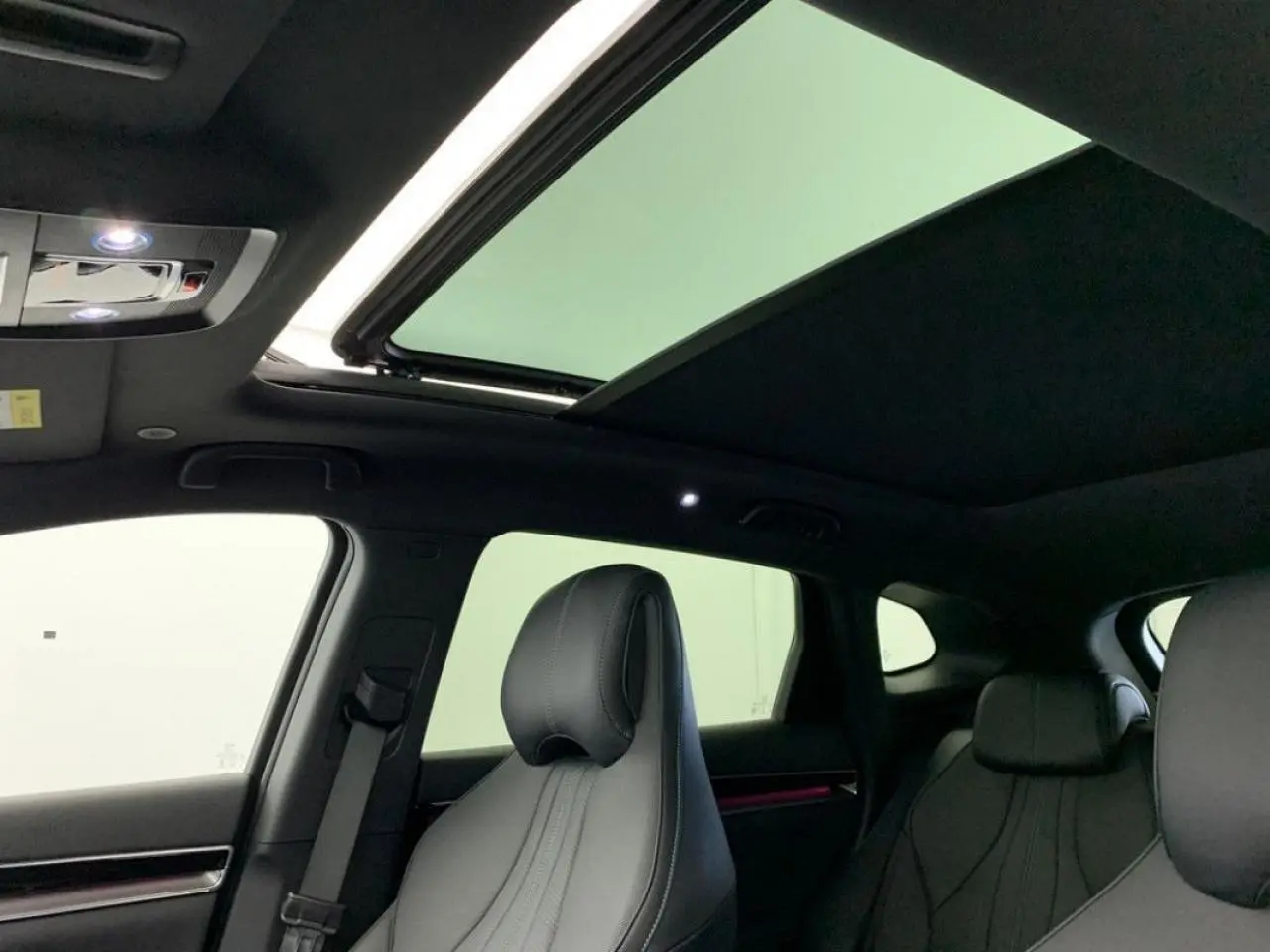 Vue intérieure montrant le toit ouvrant panoramique et les sièges avant en similicuir noir du BYD SEAL U 2025.