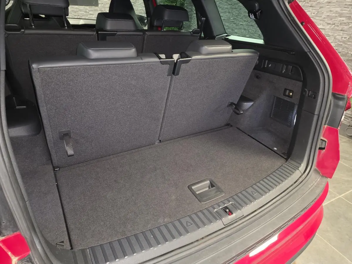 Coffre ouvert vu de l'arrière d'un Skoda Kodiaq rouge avec banquette arrière relevée et intérieur noir.