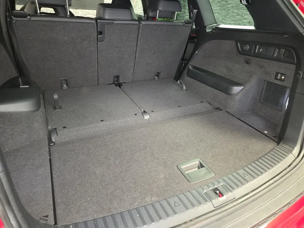 Coffre ouvert du Skoda Kodiaq rouge, vue arrière avec banquette arrière partiellement rabattue et espace de chargement plat.