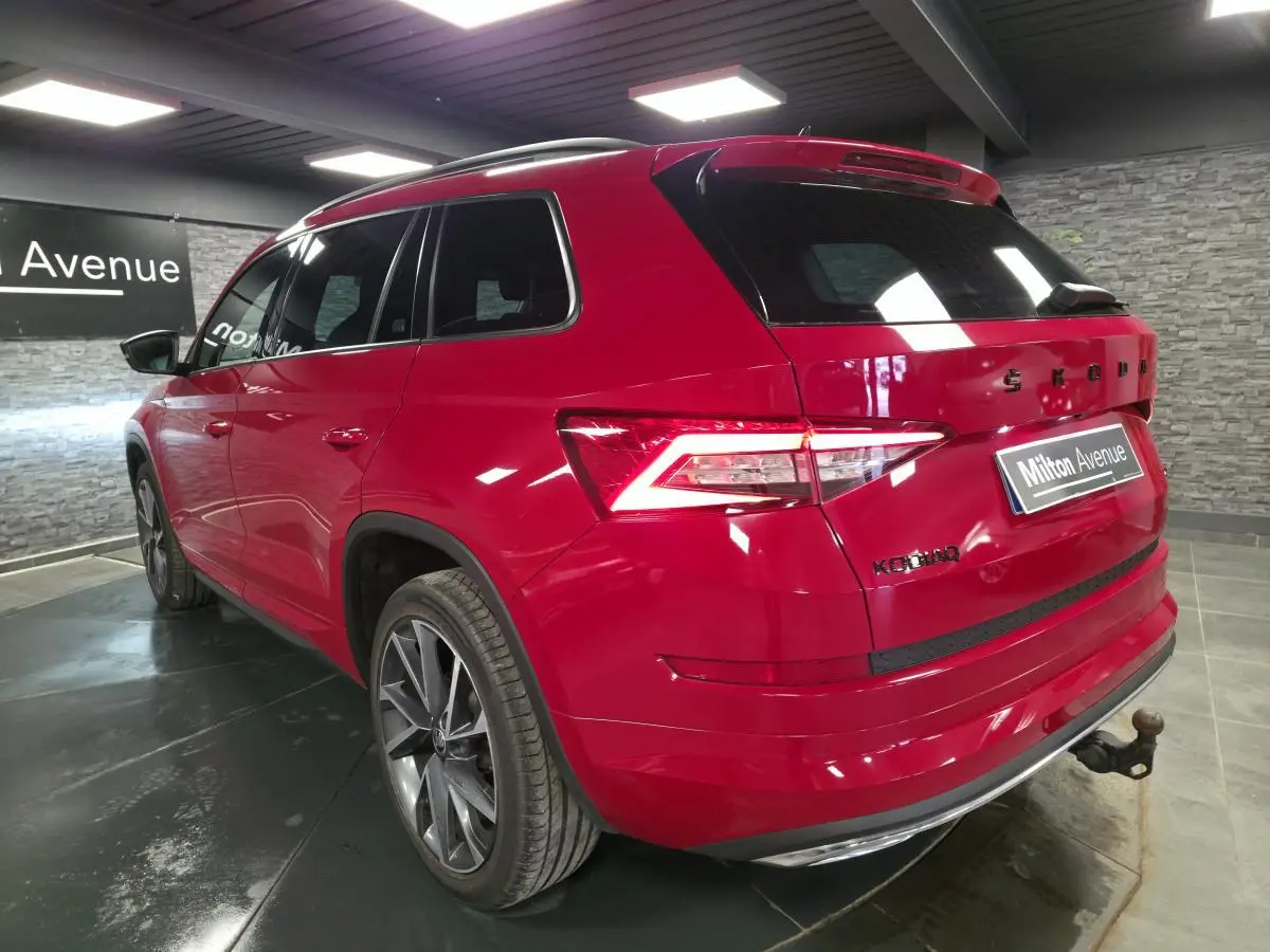 Vue 3/4 arrière droite du Skoda Kodiaq rouge 2021 avec jantes alliage 20 pouces et crochet d'attelage escamotable.