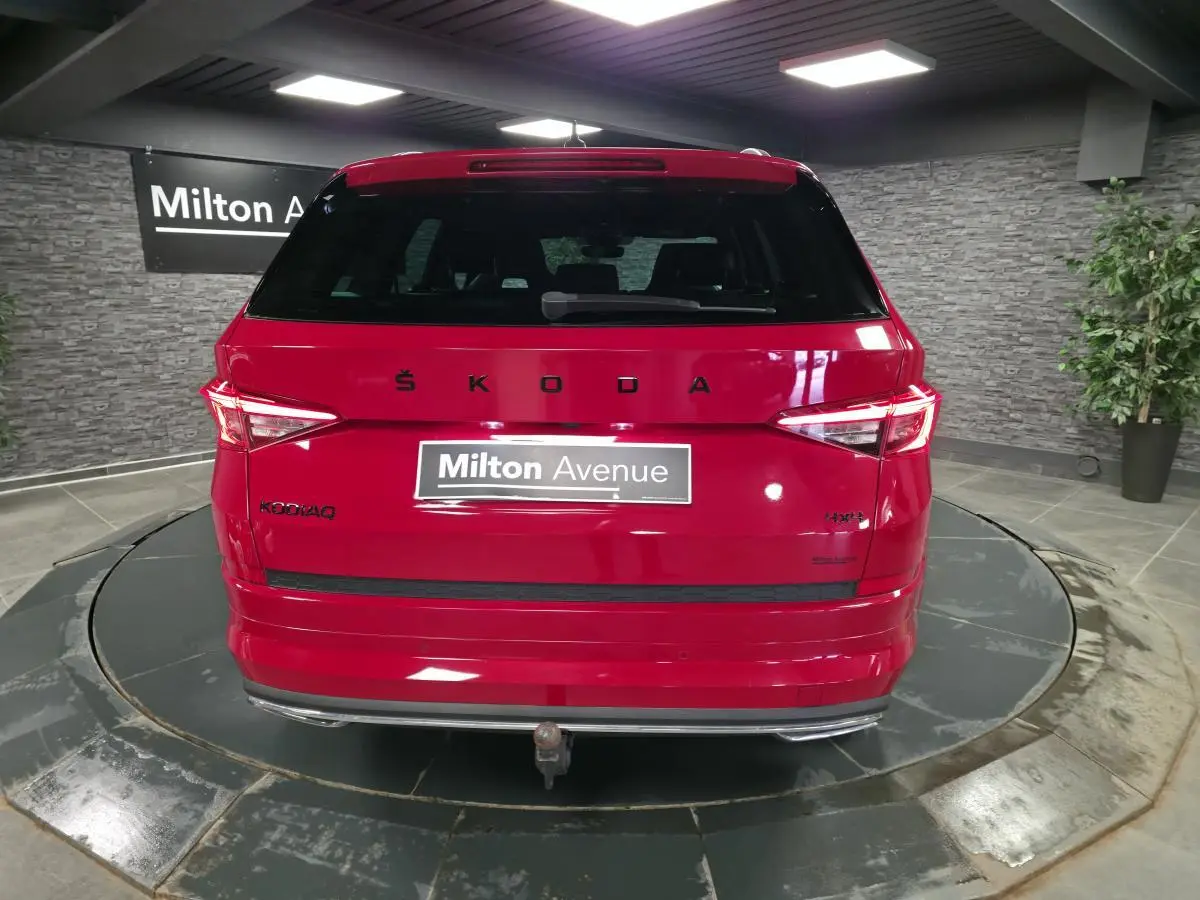 Vue arrière d'un Skoda Kodiaq rouge 2021 avec hayon électrique et crochet d'attelage escamotable visible.
