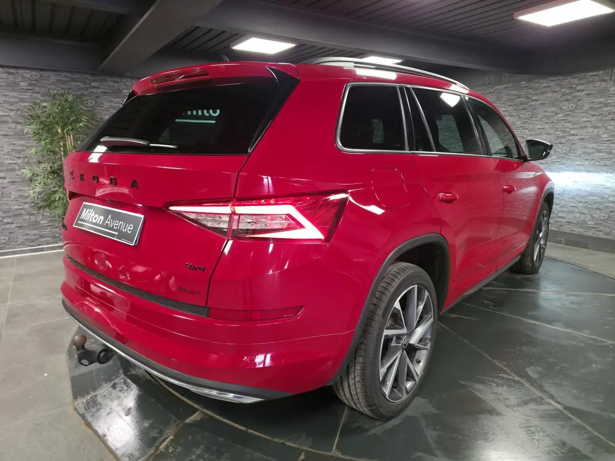 Vue 3/4 arrière droite du Skoda Kodiaq rouge avec jantes alliage 20 pouces et crochet d'attelage escamotable.