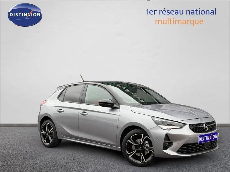 Opel Corsa 1.2 Turbo 2023 gris clair en vue 3/4 avant droit avec jantes alliage noires et toit noir.