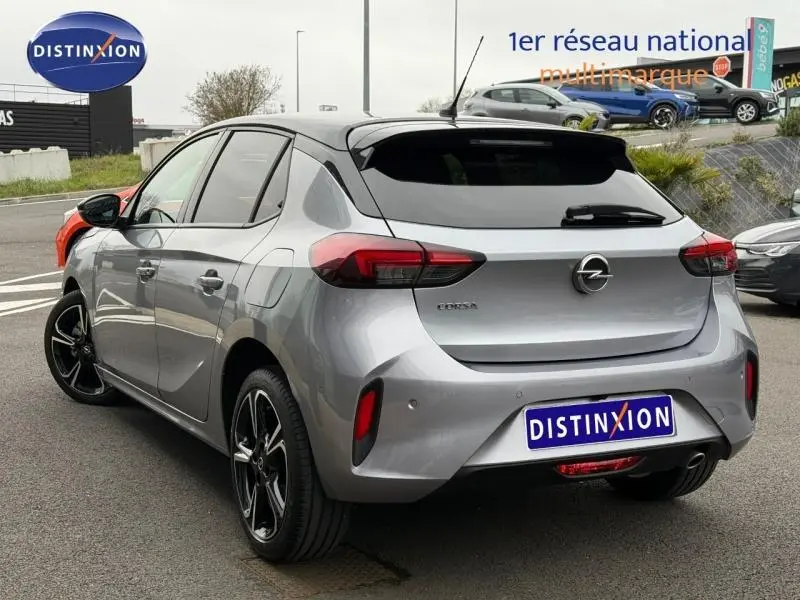 Vue 3/4 arrière droite d'une Opel Corsa 1.2 Turbo 2023 gris métallisé avec jantes alu noires et toit noir.