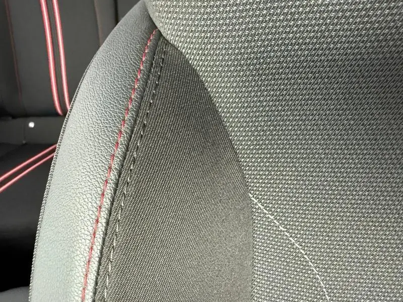Détail du siège avant sport gris avec surpiqûres rouges de l'Opel Corsa 1.2 Turbo 2023, intérieur moderne et soigné.