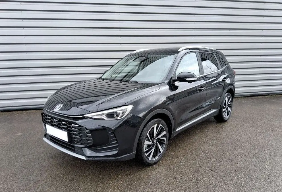 Vue 3/4 avant d'un MG ZS 1.5 Hybrid+ 197 Luxury Pebble Black avec jantes bi-ton et calandre imposante.