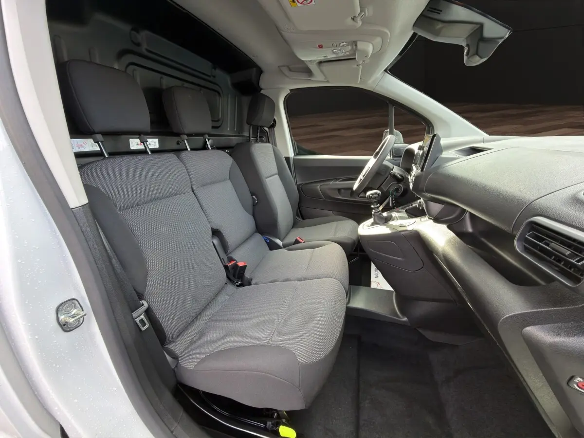 Vue intérieure côté conducteur du Citroën Berlingo blanc 2026 avec banquette 3 places et tableau de bord noir.