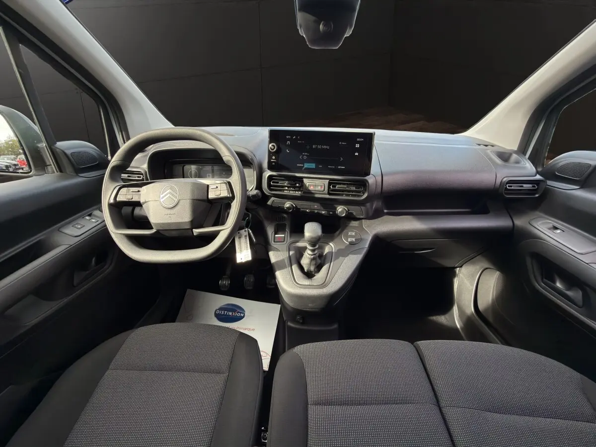 Vue intérieure avant du Citroën Berlingo blanc 2026, tableau de bord moderne avec écran tactile central et volant multifonctions.
