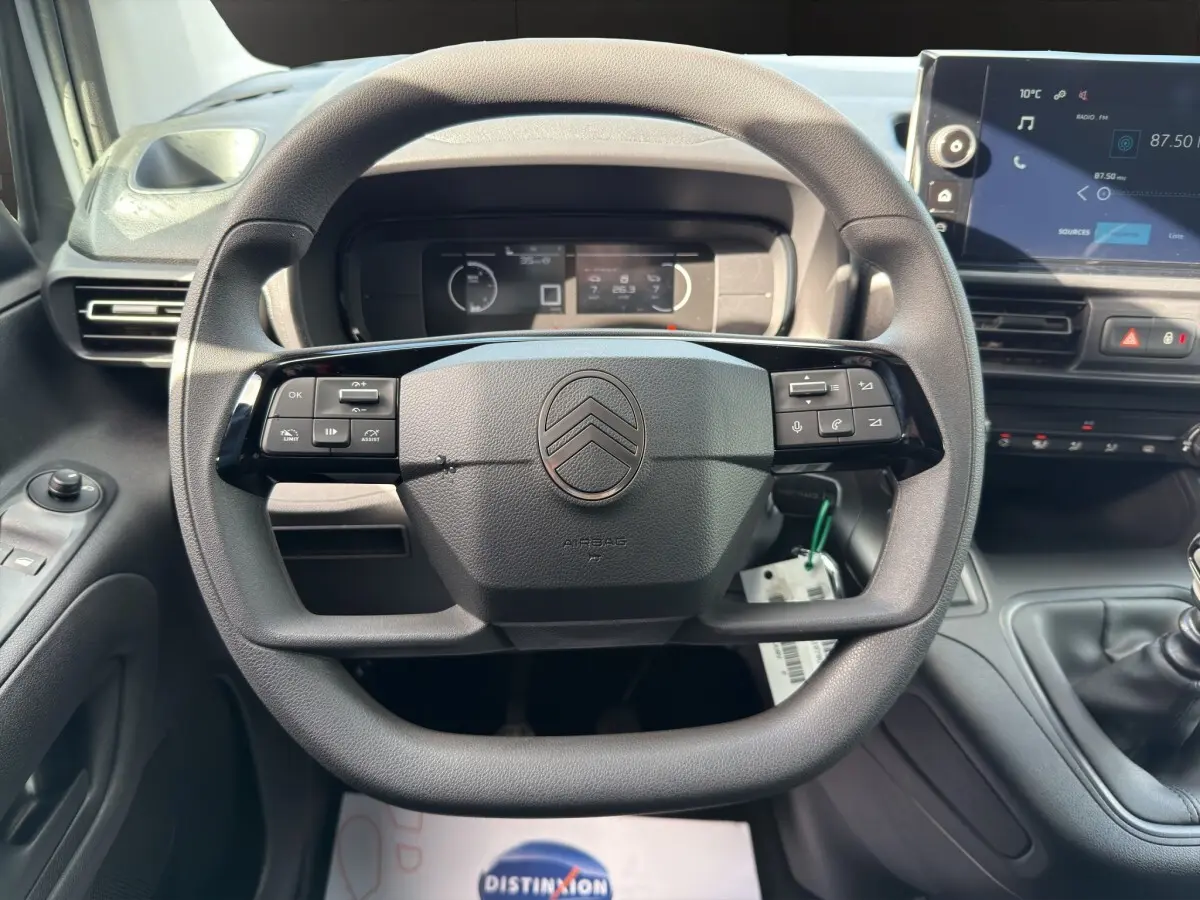 Vue intérieure centrée sur le volant multifonctions noir du Citroën Berlingo 2026 avec tableau de bord et écran tactile.