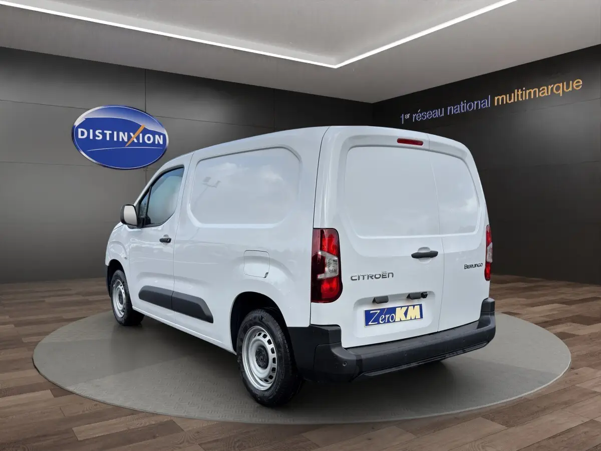 Vue 3/4 arrière droite d’un utilitaire Citroën Berlingo blanc avec panneaux latéraux pleins et pare-chocs noirs.
