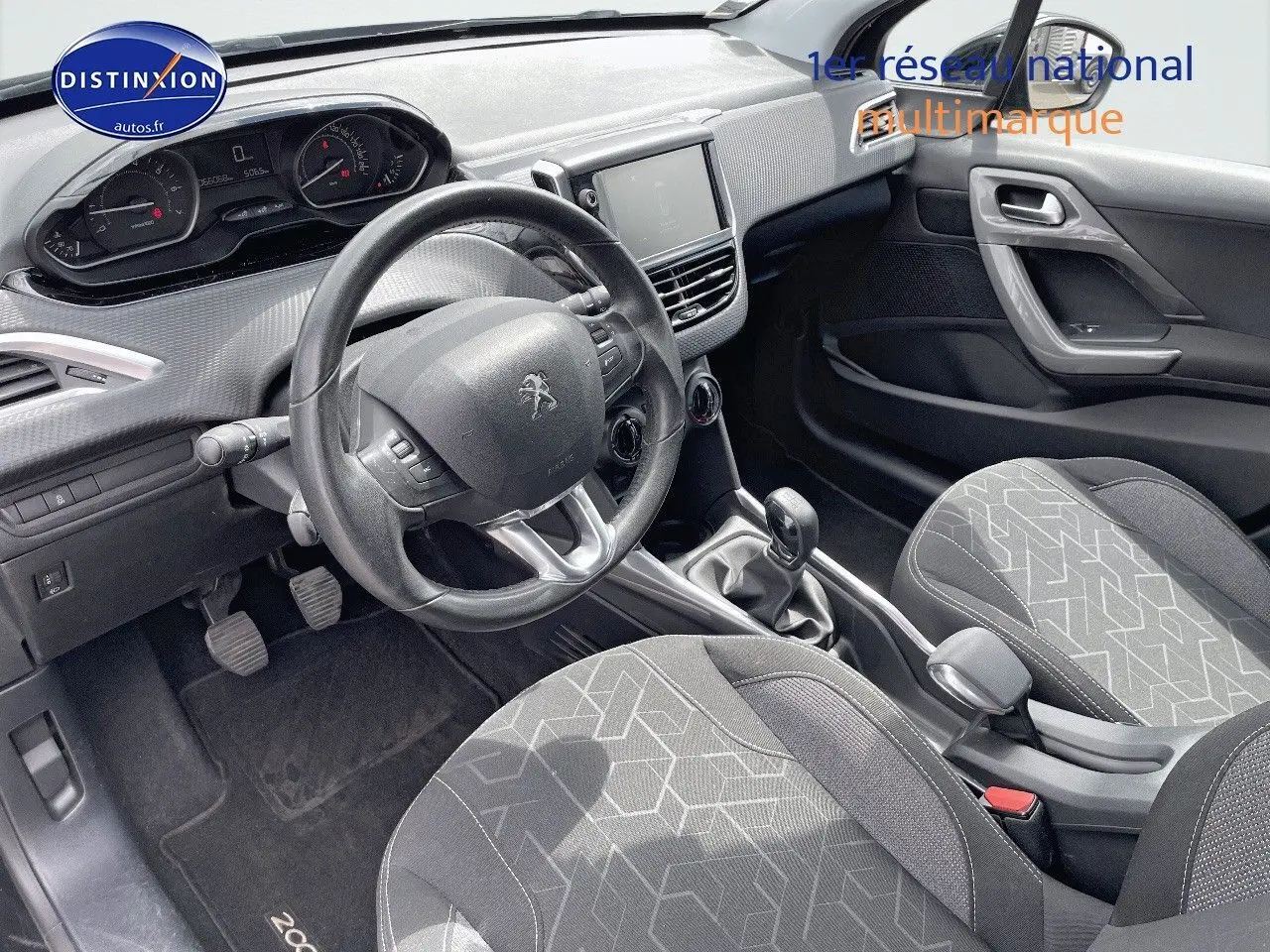 Intérieur du Peugeot 2008 noir métal 2016, vue côté conducteur montrant tableau de bord, volant et sièges tissu gris noir.