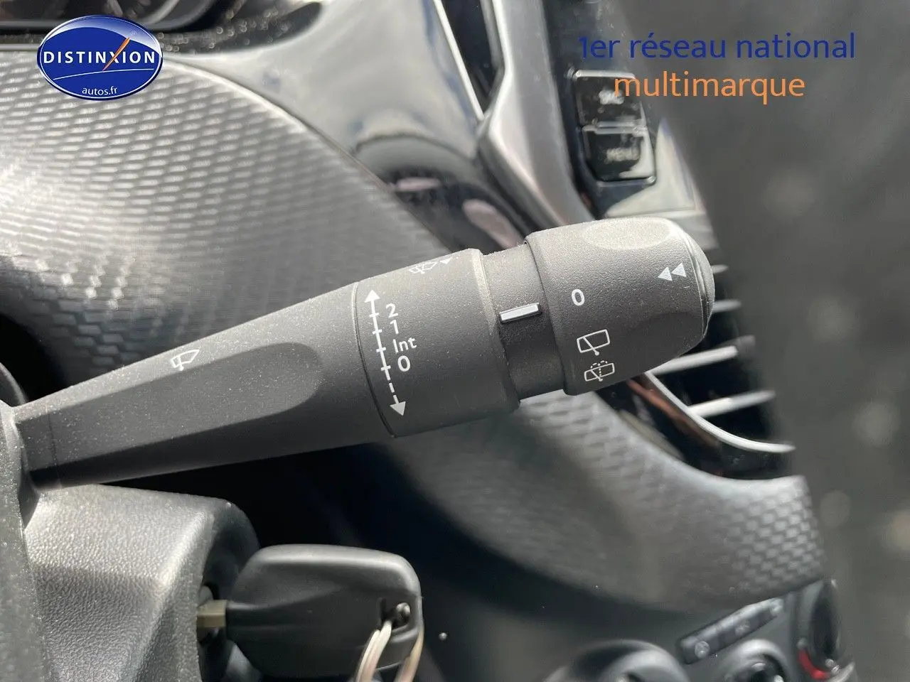 Gros plan sur la commande d'essuie-glace à gauche du volant d'une Peugeot 2008 noire métal de 2016.