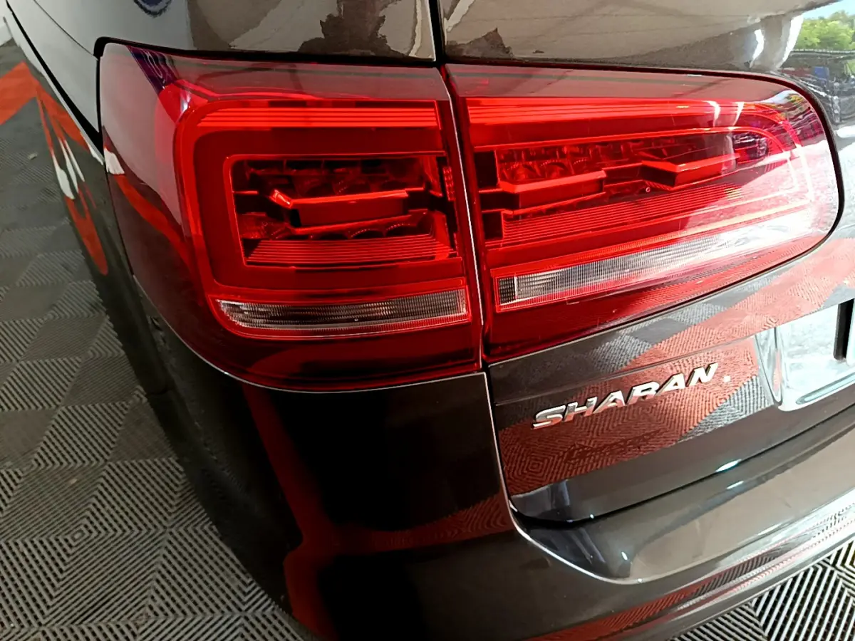 Gros plan sur le feu arrière droit rouge d’un Volkswagen Sharan marron 2017 avec logo Sharan visible sur le hayon.