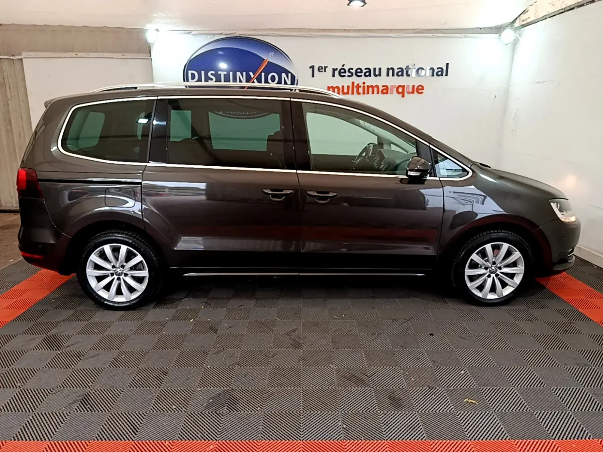 Vue de profil côté gauche d’un Volkswagen Sharan marron 2017, avec jantes alliage et portes coulissantes visibles.