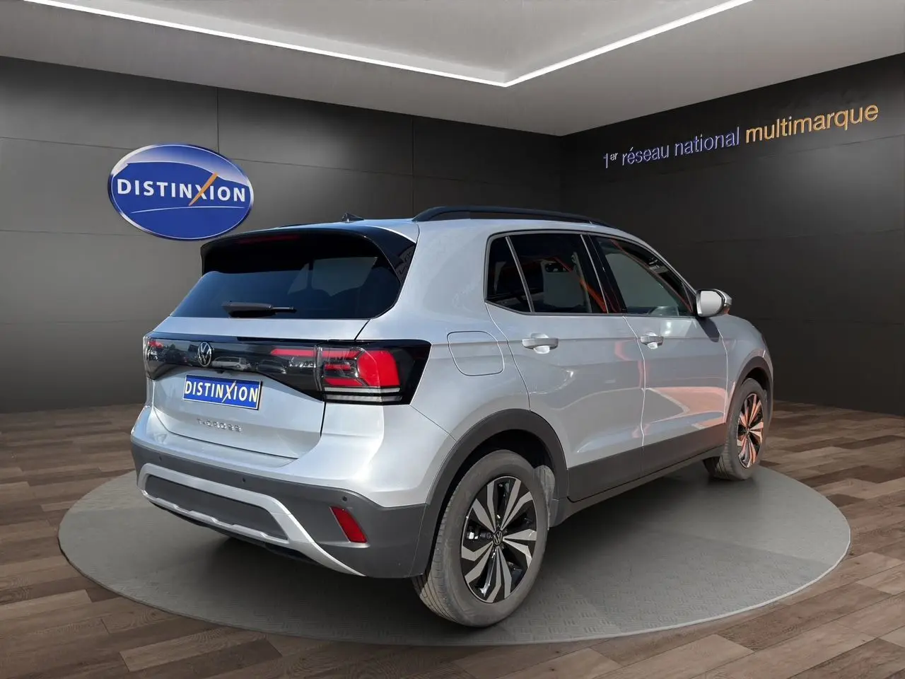 Vue 3/4 arrière droite d'un Volkswagen T-Cross 2025 reflet d'argent avec jantes alliage et vitres surteintées.