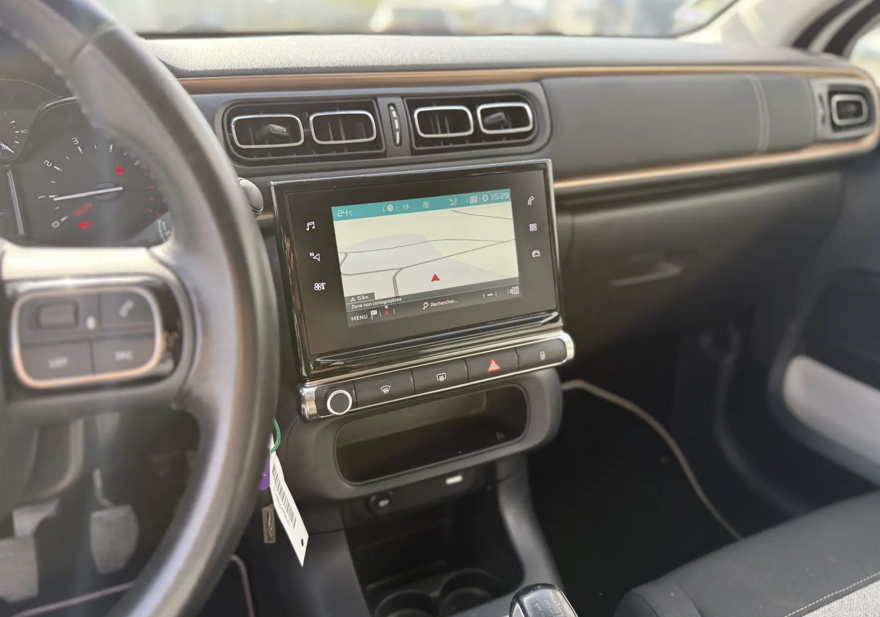 Vue intérieure côté conducteur du tableau de bord de la Citroën C3 1.2 PureTech 83 Origins avec écran tactile et volant noir.