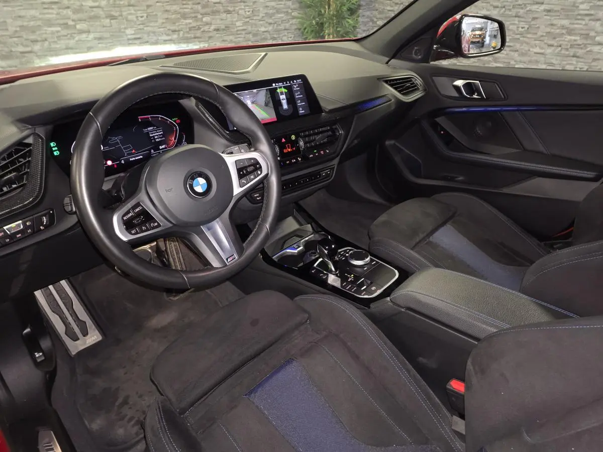 Vue intérieure côté conducteur de la BMW Série 1 116d M Sport 2024 avec sellerie Alcantara noire et tableau de bord numérique.