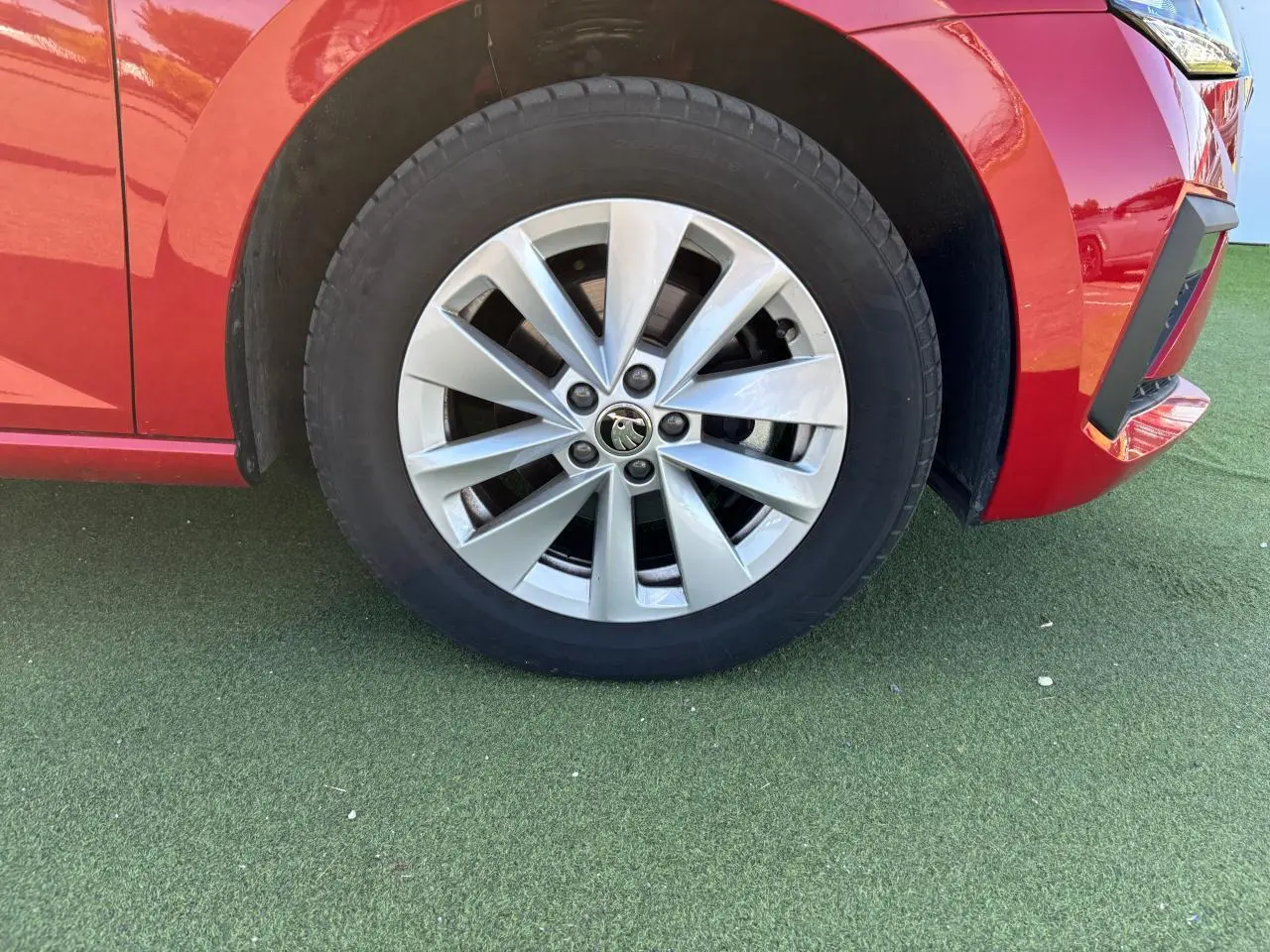 Gros plan sur la roue avant droite avec jante alliage 16 pouces Cortadero Aero d'une SKODA SCALA rouge Velvet Metal.