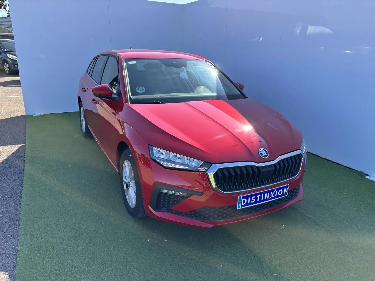 SKODA SCALA rouge Velvet Metal vue 3/4 avant droit, calandre noire et phares LED distinctifs visibles.