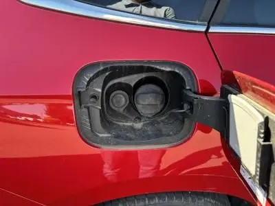 Gros plan sur la trappe de carburant ouverte d'une Skoda Scala rouge velvet metal côté gauche arrière.