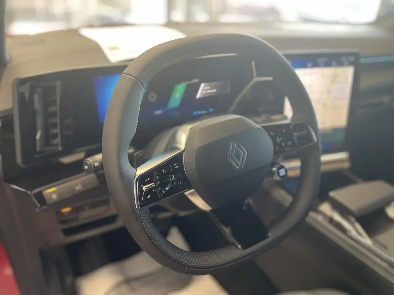 Gros plan sur le volant textile refined noir du Renault Rafale 2025 avec tableau de bord numérique et écran tactile multimédia.