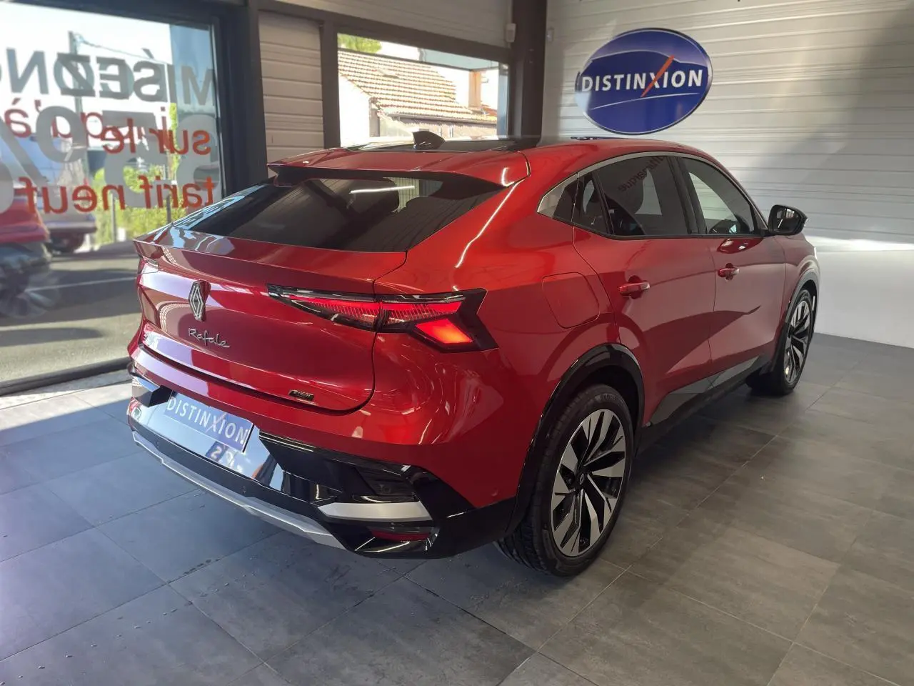 Vue 3/4 arrière droite du Renault Rafale 2025 rouge à toit noir avec jantes alliage et feux LED distinctifs.