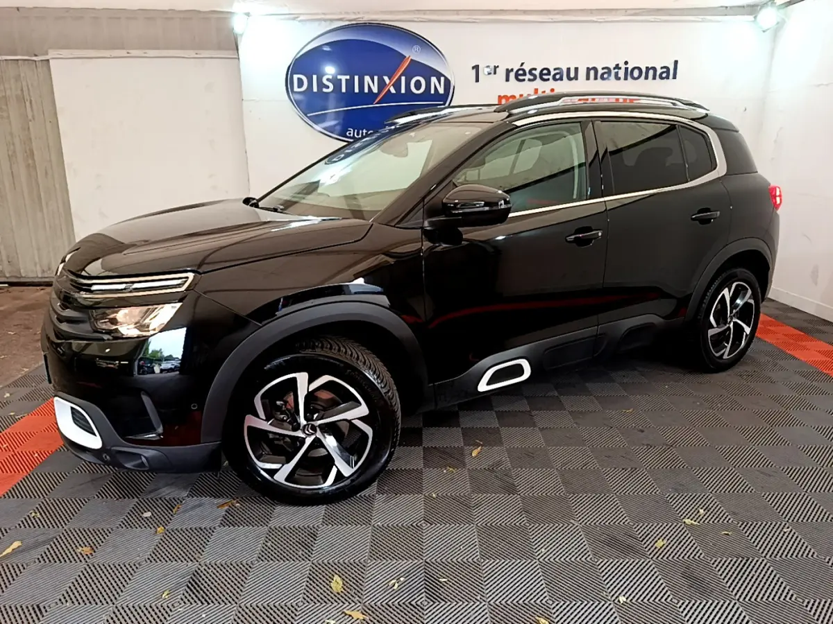 Vue 3/4 avant droit d'un Citroën C5 Aircross noir avec jantes alliage et détails blancs sur boucliers et bas de caisse.