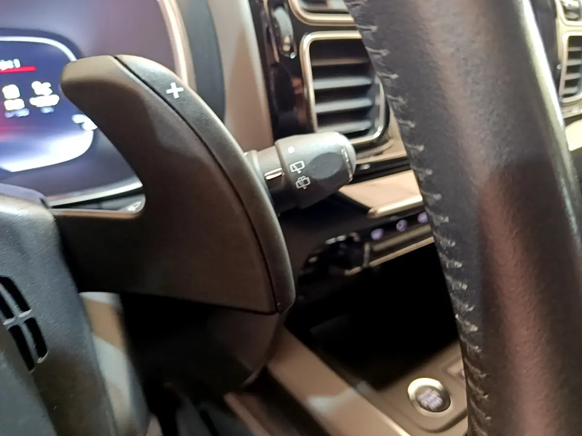 Gros plan sur la palette de changement de vitesse droite et partie du volant cuir noir du Citroën C5 Aircross 2020.