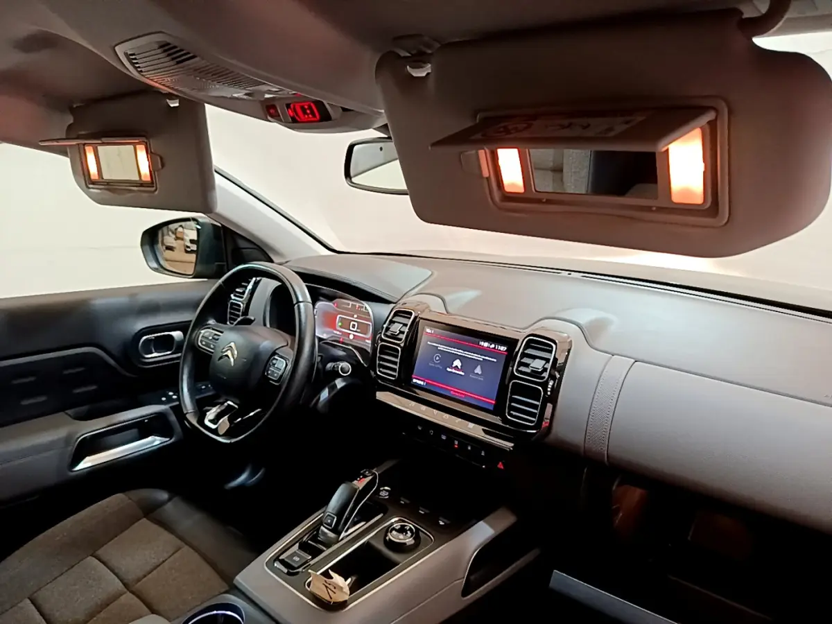 Intérieur avant droit du Citroën C5 Aircross noir 2020, volant cuir, écran tactile et miroirs de courtoisie éclairés.